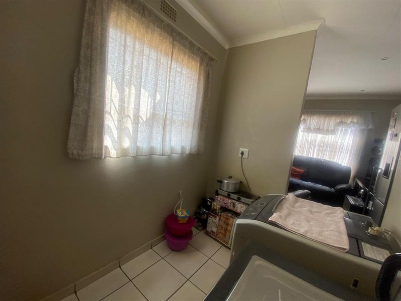 A functional laundry area featuring tiled flooring and a window, providing a practical space for household utility tasks.