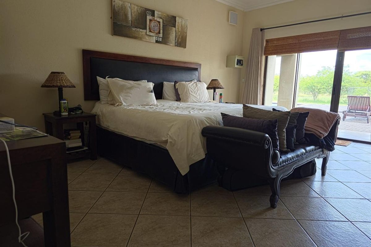 Spacious bedroom featuring ceramic floor tiles and a large sliding glass door providing direct access to the outdoor patio area.