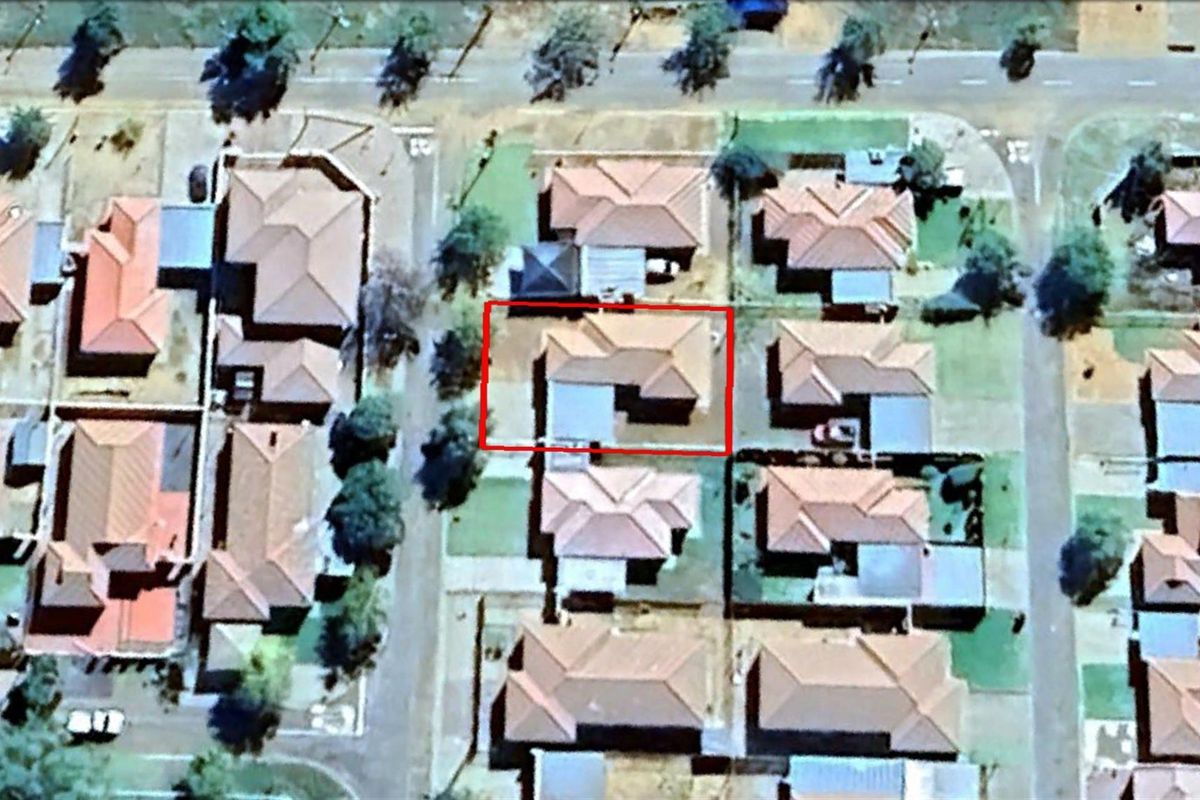 An aerial view of the residential property highlighted within a red boundary, showing its position and layout within the surrounding suburban neighborhood.