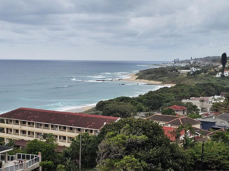 Elevated coastal view overlooking the ocean, sandy beach, and surrounding residential neighborhood.