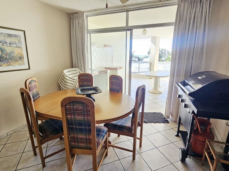 Dining area featuring tiled flooring and sliding glass doors providing direct access to a covered balcony.