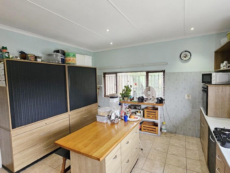 Functional kitchen featuring built-in cabinetry, a central island, tiled flooring, and a built-in oven with gas hob.