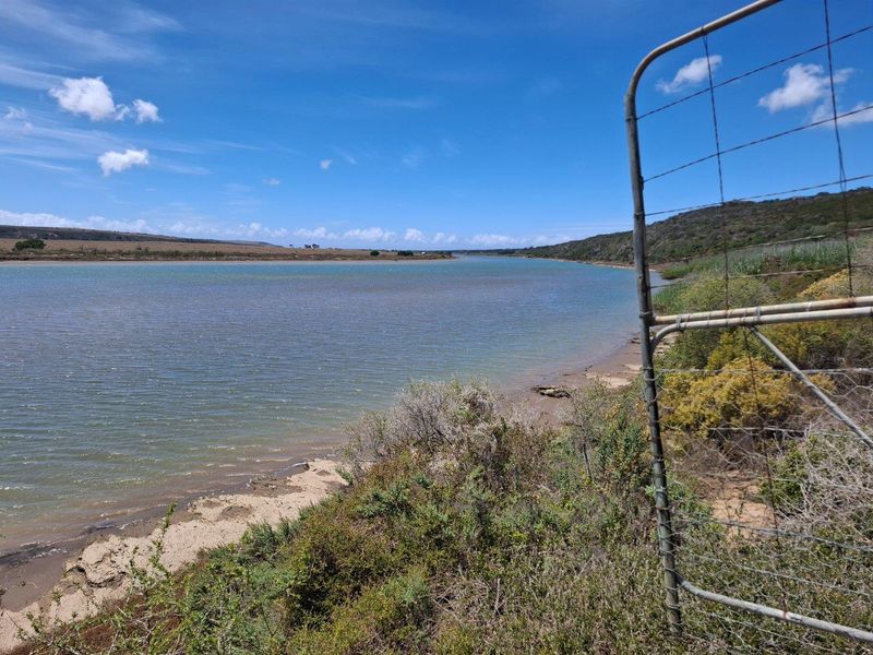 Scenic view of the river and natural landscape from the farm property, featuring a metal wire boundary fence.