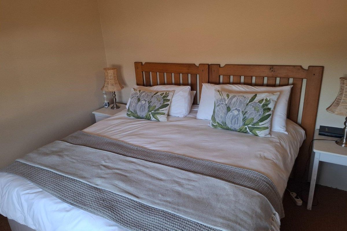 A bedroom featuring neutral wall tones and carpeted flooring, providing a simple and functional sleeping space.