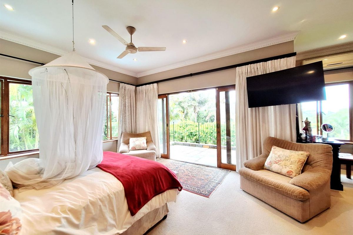 Spacious bedroom featuring a ceiling fan, recessed lighting, and large sliding glass doors that open directly onto a private patio area.