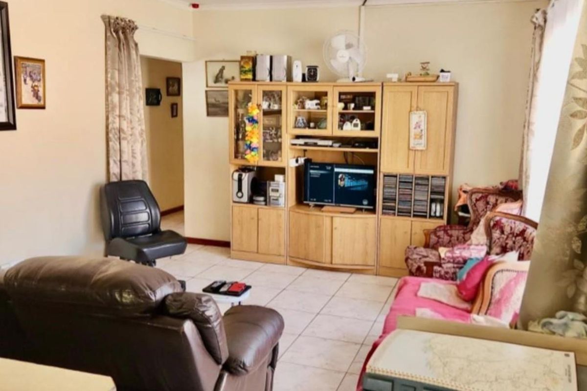 A functional living room featuring tiled flooring and neutral wall tones, providing a comfortable and versatile space for relaxation.