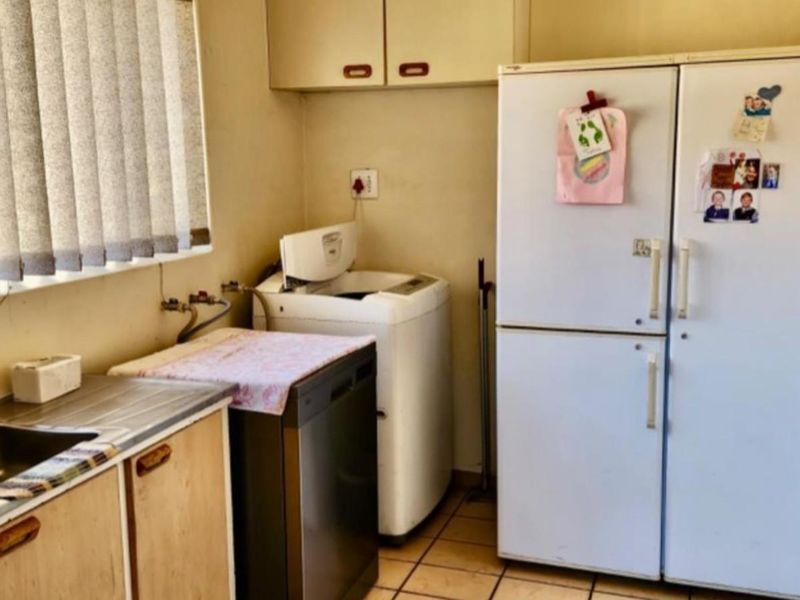 Functional laundry area featuring built-in cabinetry, a stainless steel sink, and dedicated plumbing connections for appliances.