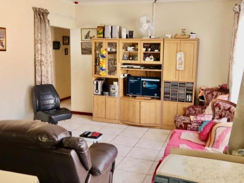 A functional living room featuring tiled flooring and neutral wall tones, providing a comfortable and versatile space for relaxation.