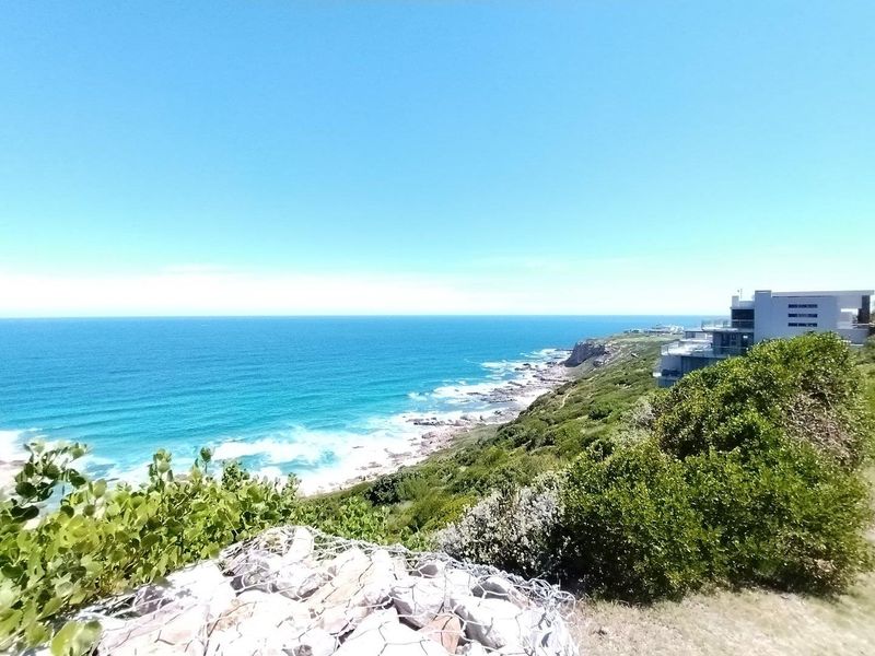 A stunning elevated coastal view overlooking the ocean, rocky shoreline, and surrounding natural landscape from the residential property.