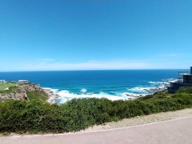 A stunning elevated coastal view overlooking the ocean, rocky shoreline, and surrounding natural landscape from the property.
