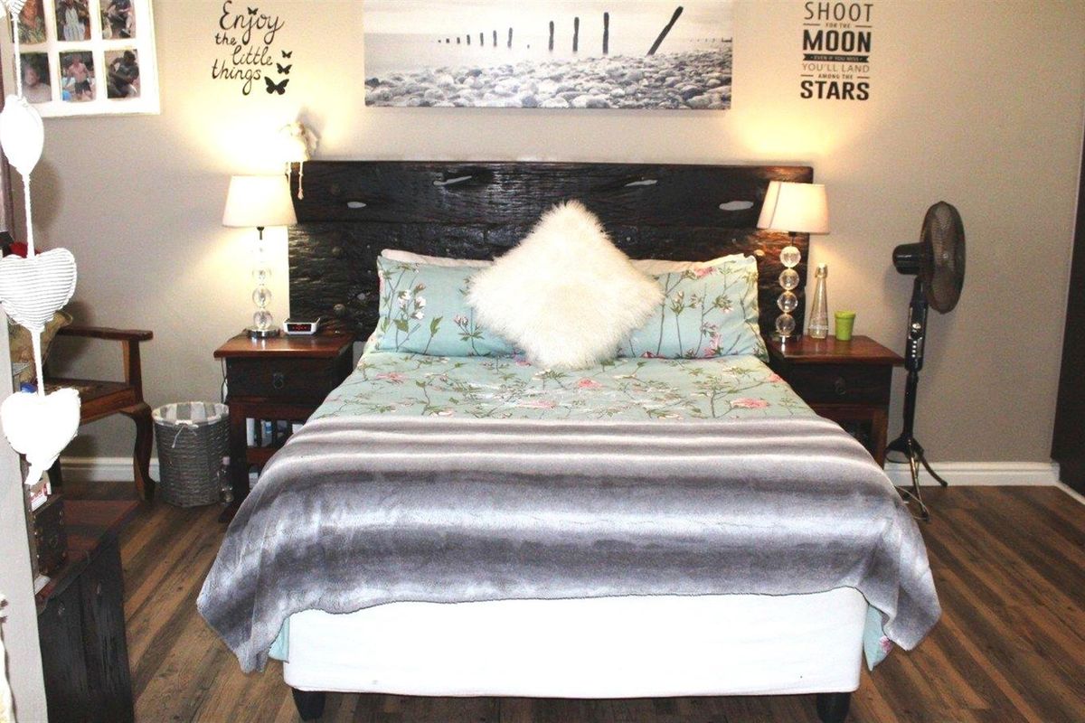 A bedroom featuring laminate flooring and a built-in wardrobe, providing a functional and comfortable sleeping space.