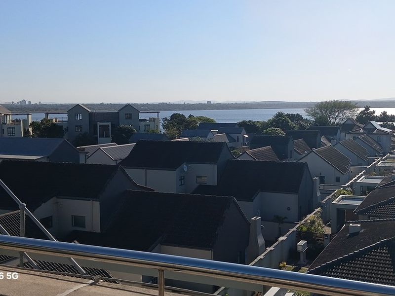Elevated view overlooking a residential estate with a scenic water backdrop.