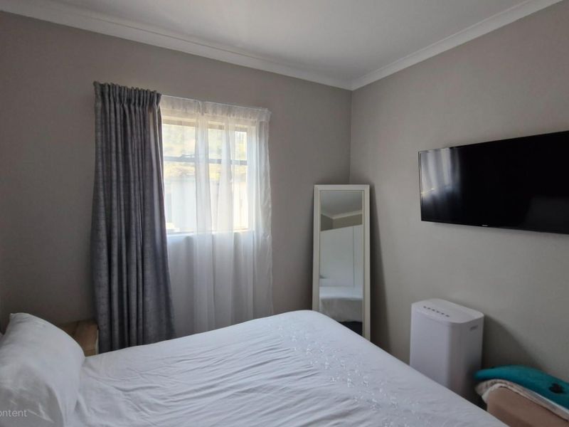 A well-maintained bedroom featuring neutral wall tones, coving, and window treatments, providing a comfortable and functional living space.