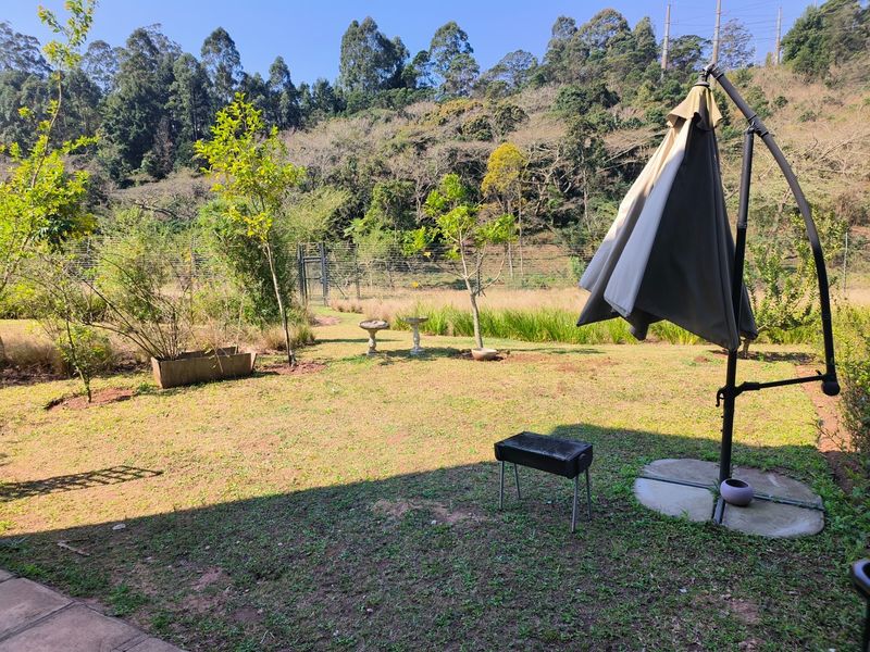A private garden area featuring a lawn and perimeter fencing, offering a peaceful outdoor space with natural surroundings.