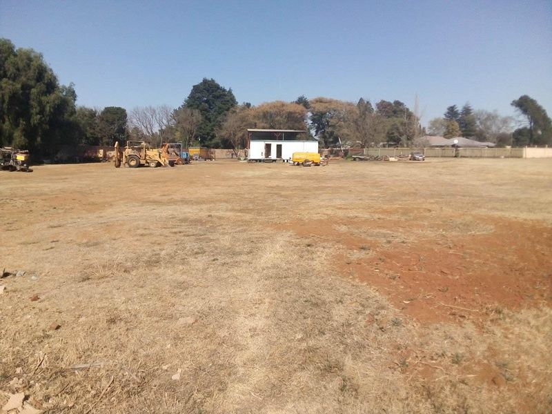 Expansive industrial land plot featuring a small modular structure and open yard space, suitable for various commercial or industrial development opportunities.