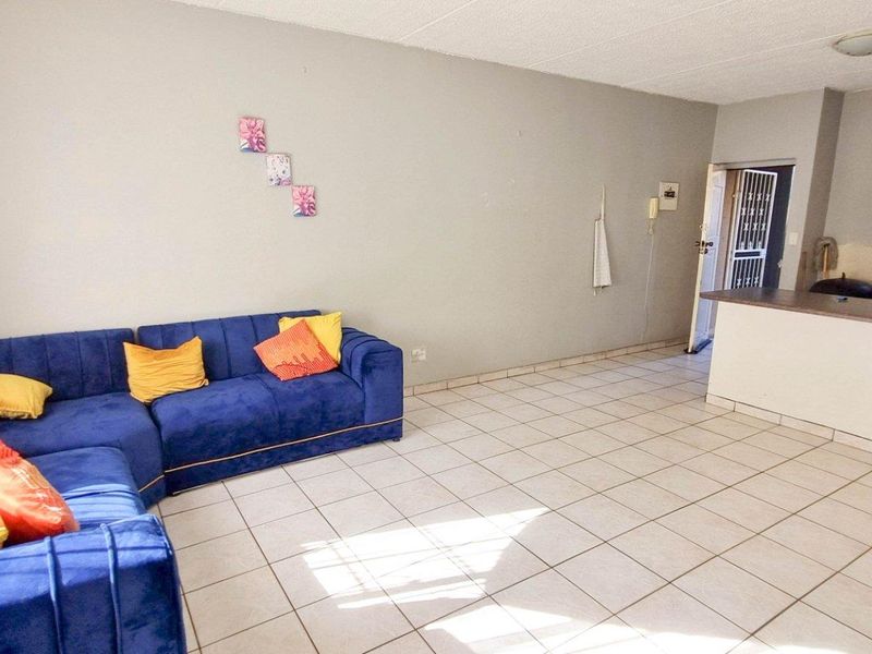 Open plan living area featuring tiled flooring and a breakfast bar counter connecting to the kitchen space.