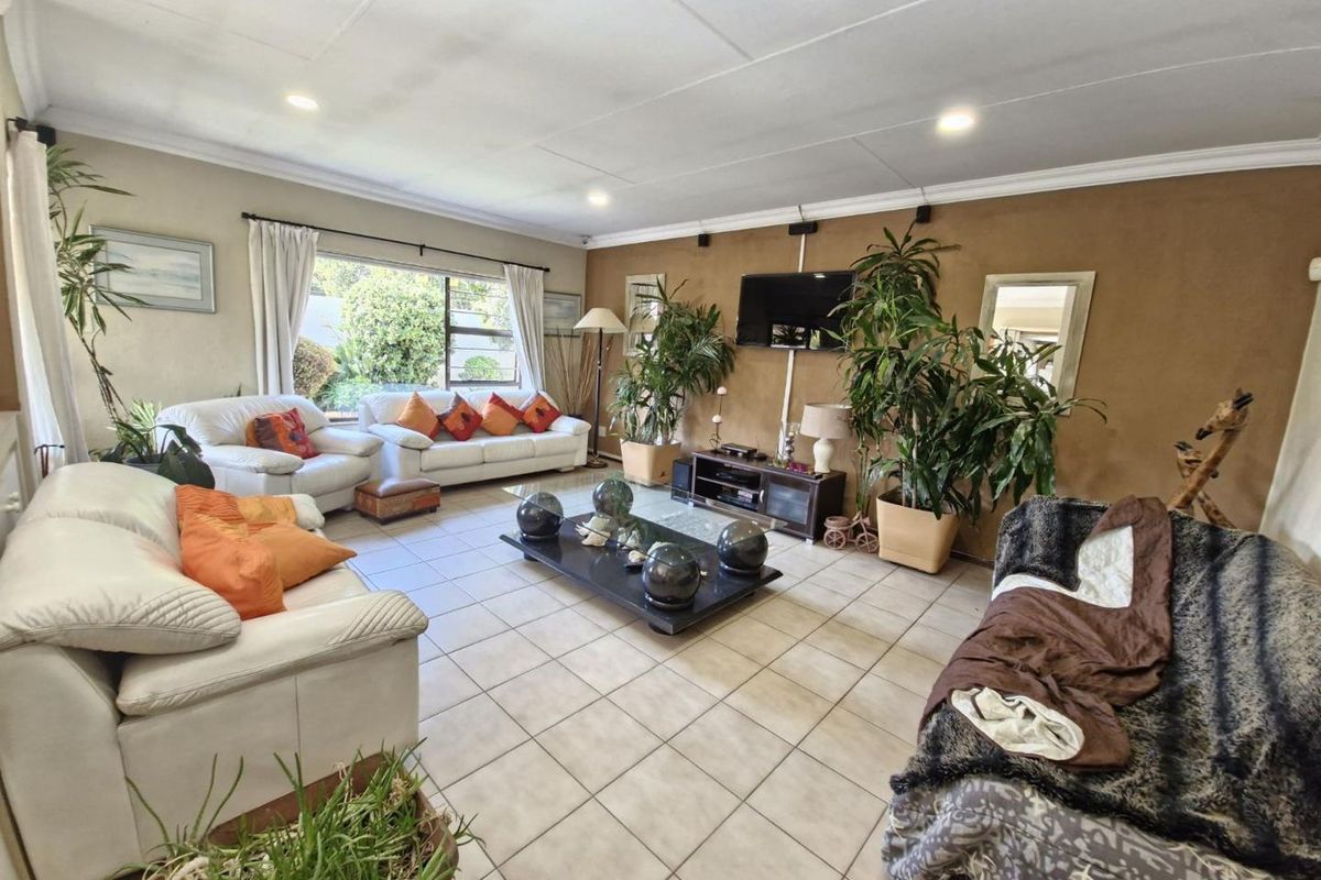 Spacious living room featuring tiled flooring, recessed ceiling lighting, and large windows providing natural light.