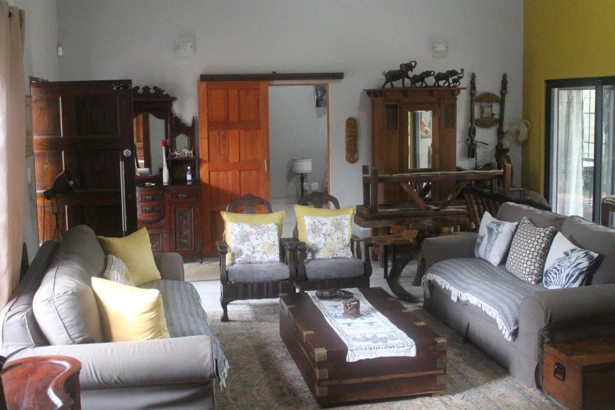 A spacious living room featuring tiled flooring, sliding wooden doors, and access to an outdoor area through a sliding glass door.