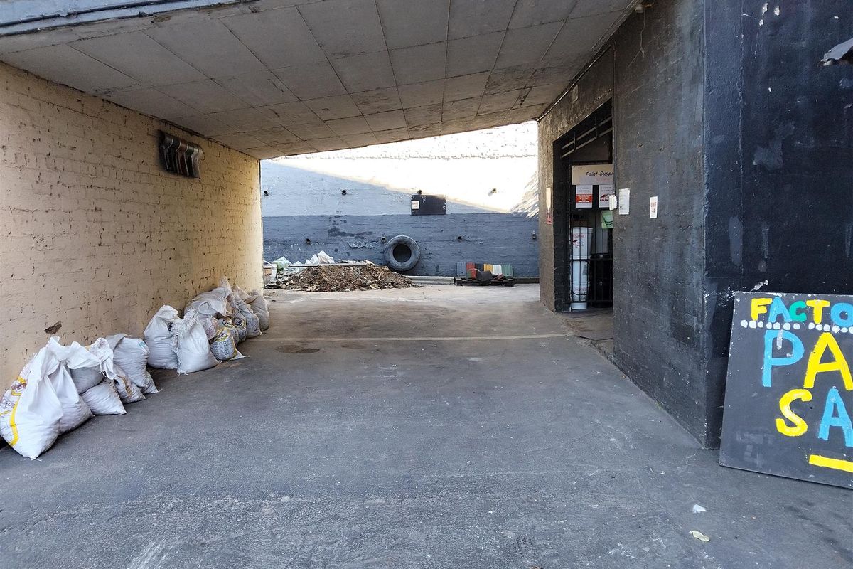 Covered industrial loading or access area with concrete flooring and masonry walls, providing functional space for logistics and site access.