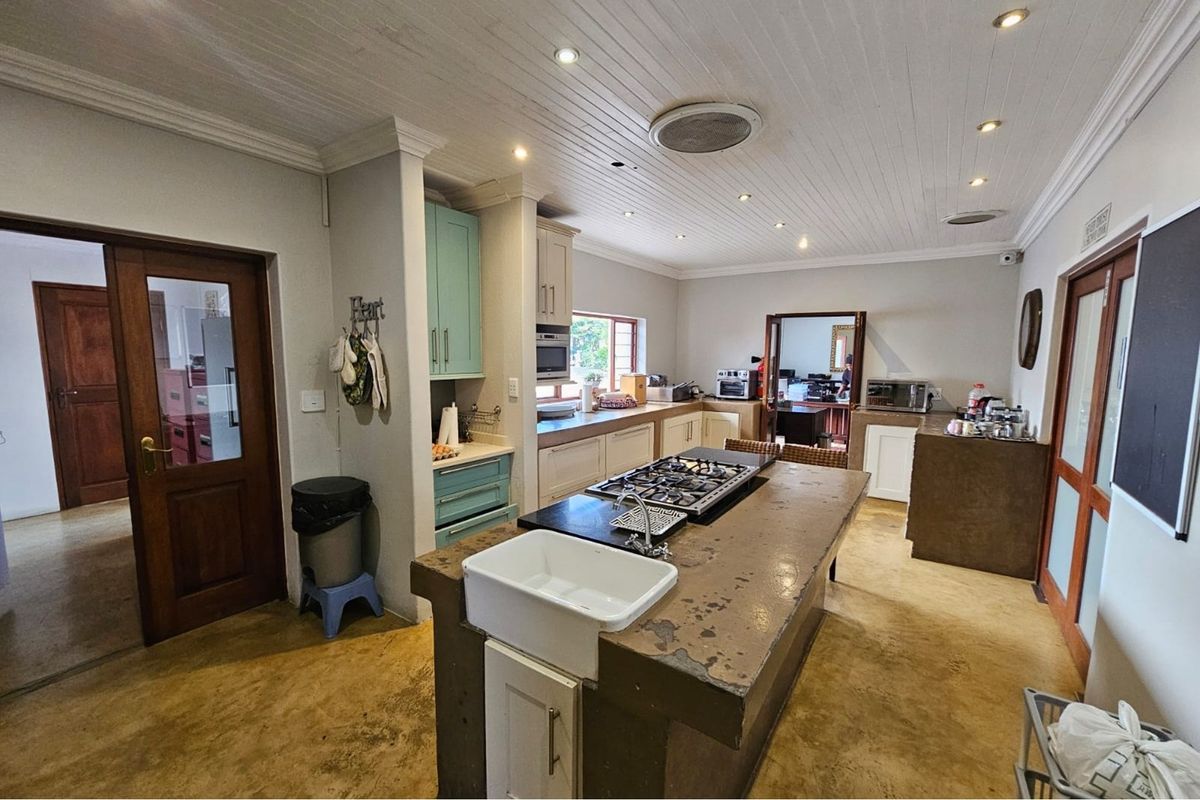 Spacious kitchen featuring a central island with a farmhouse sink and integrated gas hob, complemented by built-in cabinetry and recessed ceiling lighting.