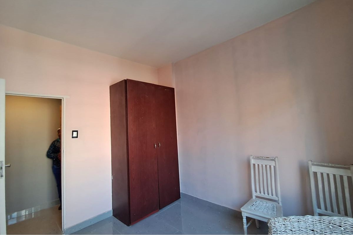 A simple interior room featuring tiled flooring and a neutral wall finish, suitable for use as a bedroom or office space.
