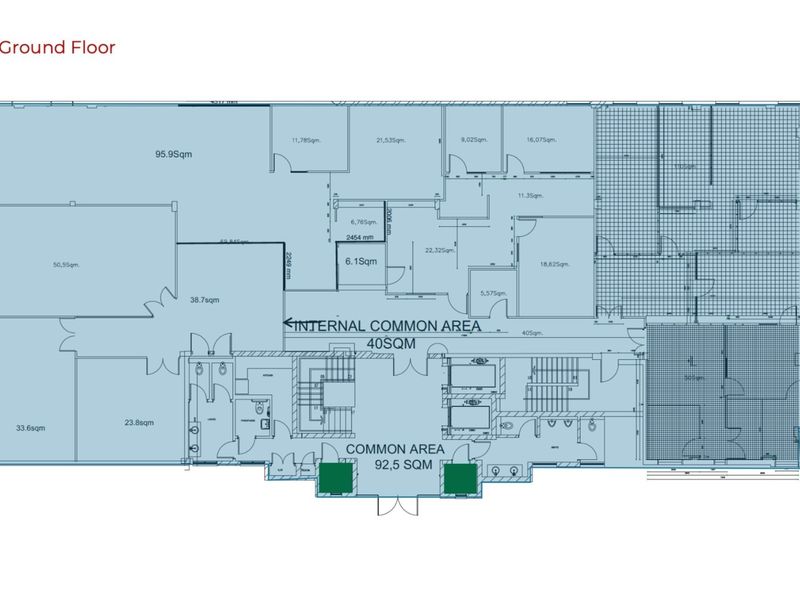 Ground floor architectural layout plan showing office spaces, common areas, staircases, and elevator access points.