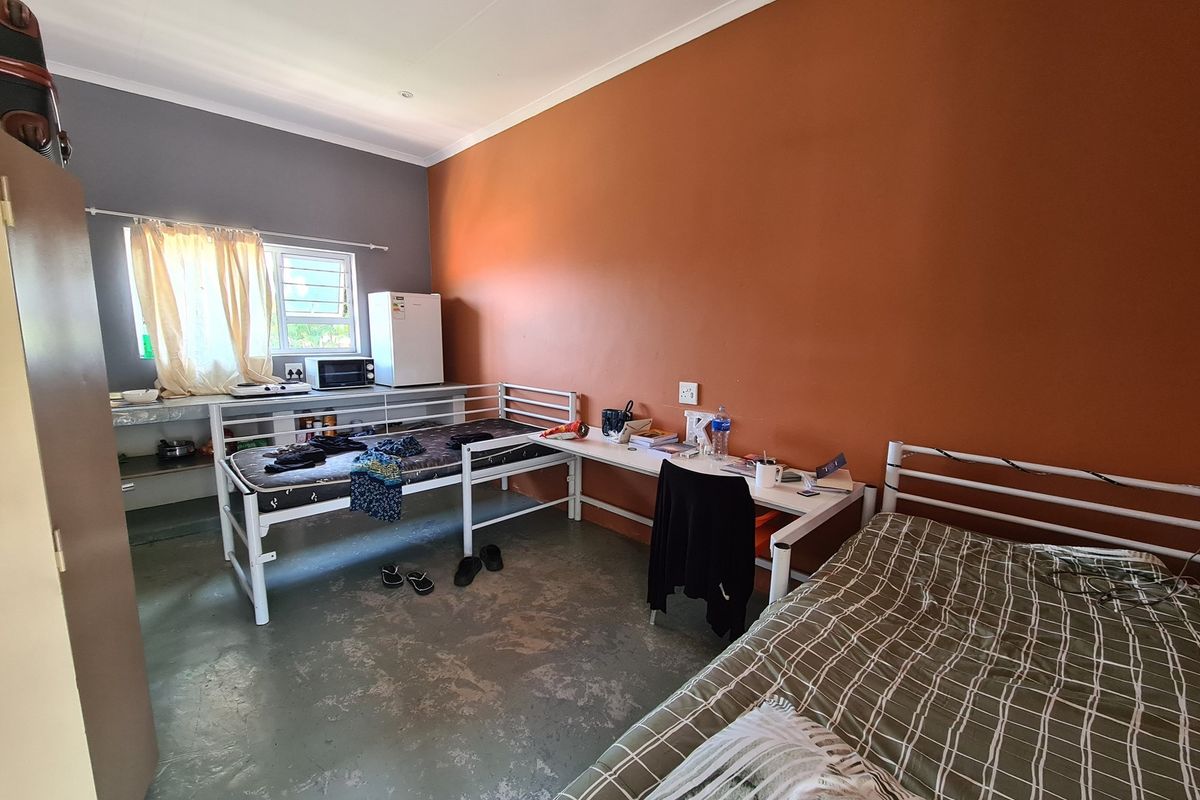 A functional bedroom space featuring a kitchenette area with a sink and counter, suitable for student or compact commercial accommodation.