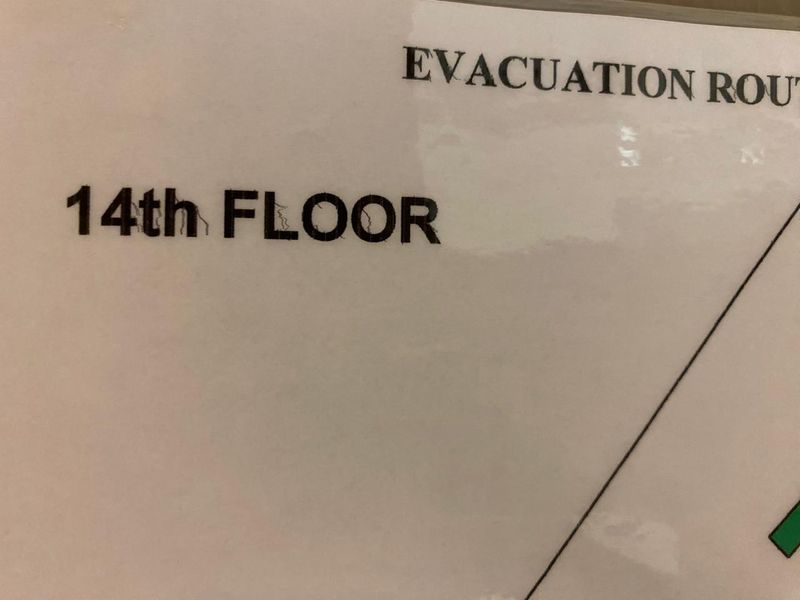 A close-up view of an evacuation route sign indicating the 14th floor of the office building.