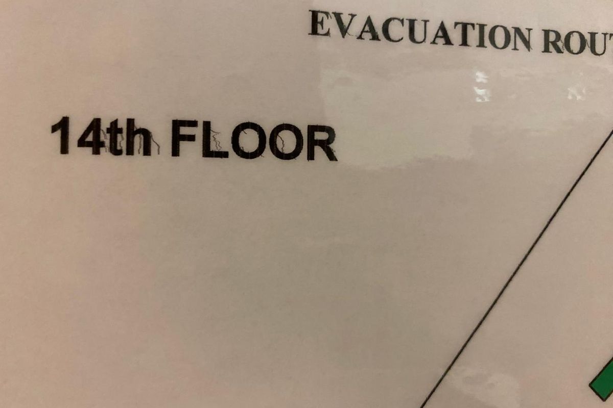 A close-up view of an evacuation route sign indicating the 14th floor of the office building.
