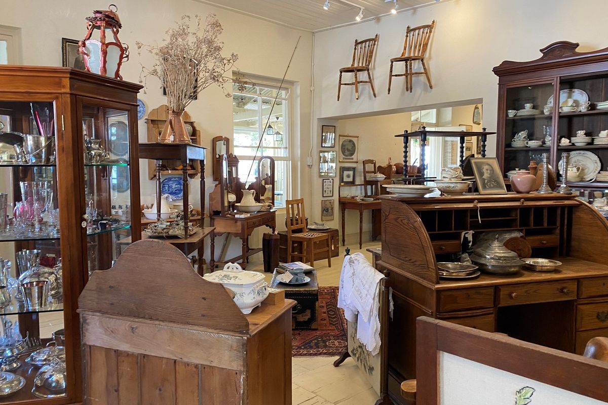A spacious interior room featuring high ceilings, timber flooring, and large windows, currently utilized as a retail display area.