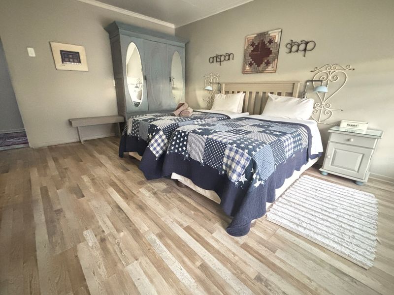 A bedroom featuring light-toned wood-look flooring and neutral wall finishes, providing a comfortable and functional space.