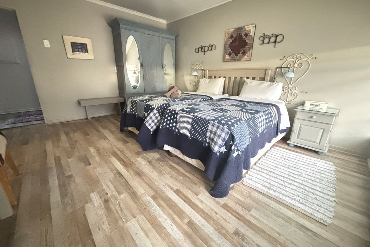 A bedroom featuring light-toned wood-look flooring and neutral wall finishes, providing a comfortable and functional space.