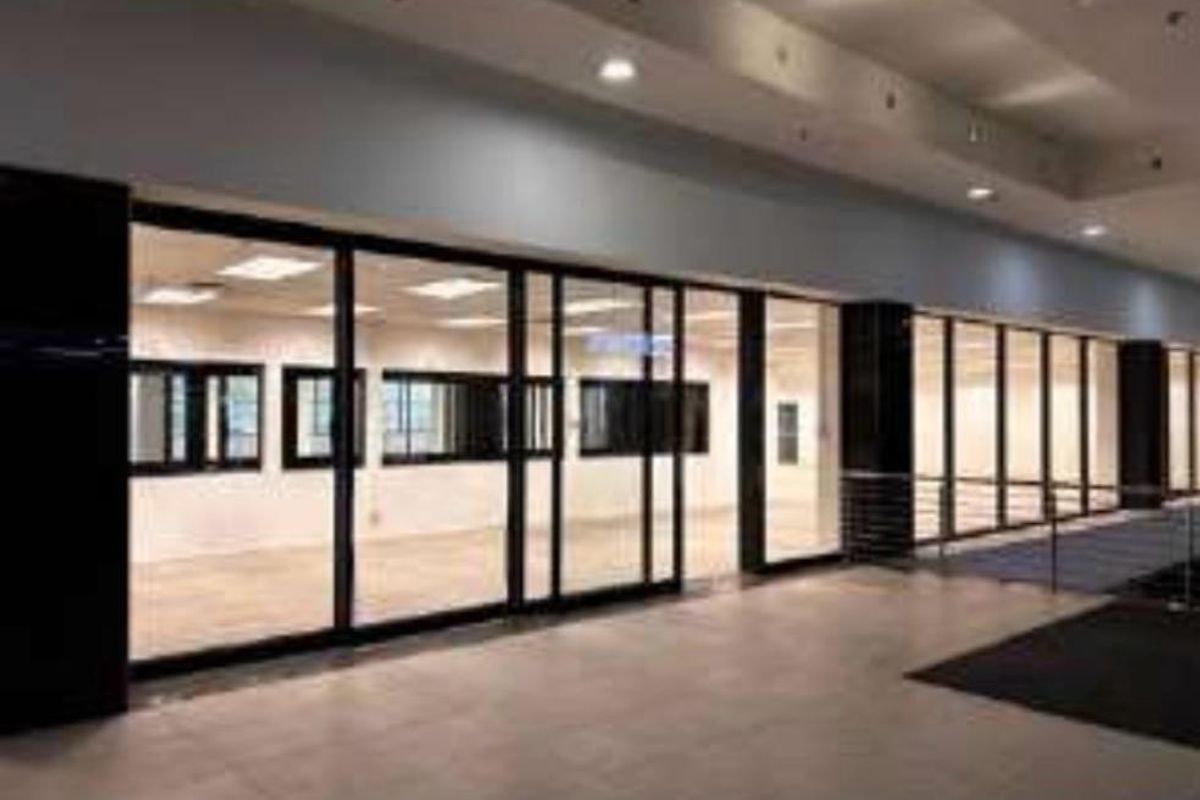 Spacious open-plan retail unit featuring a modern glass storefront, recessed lighting, and neutral tiled flooring, suitable for various commercial business applications.