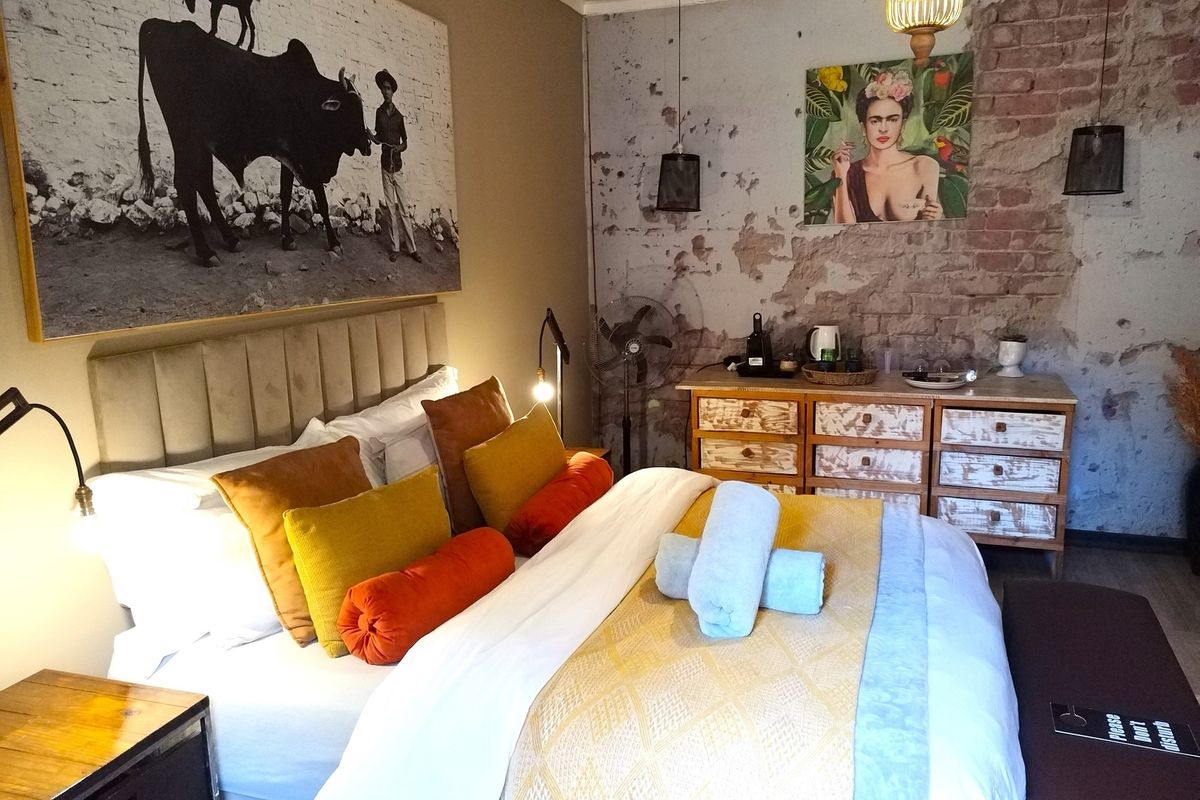 A bedroom featuring an exposed brick wall, neutral tones, and a built-in dresser, offering a rustic and characterful guest house accommodation.