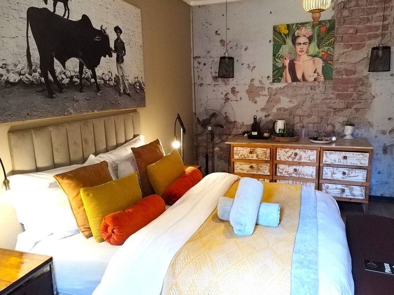 A bedroom featuring an exposed brick wall, neutral tones, and a built-in dresser, offering a rustic and characterful guest house accommodation.