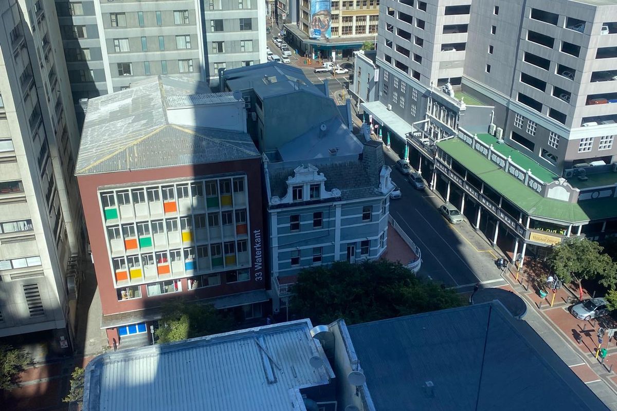 An elevated aerial view of the urban streetscape, showcasing surrounding commercial buildings and the street-level environment.