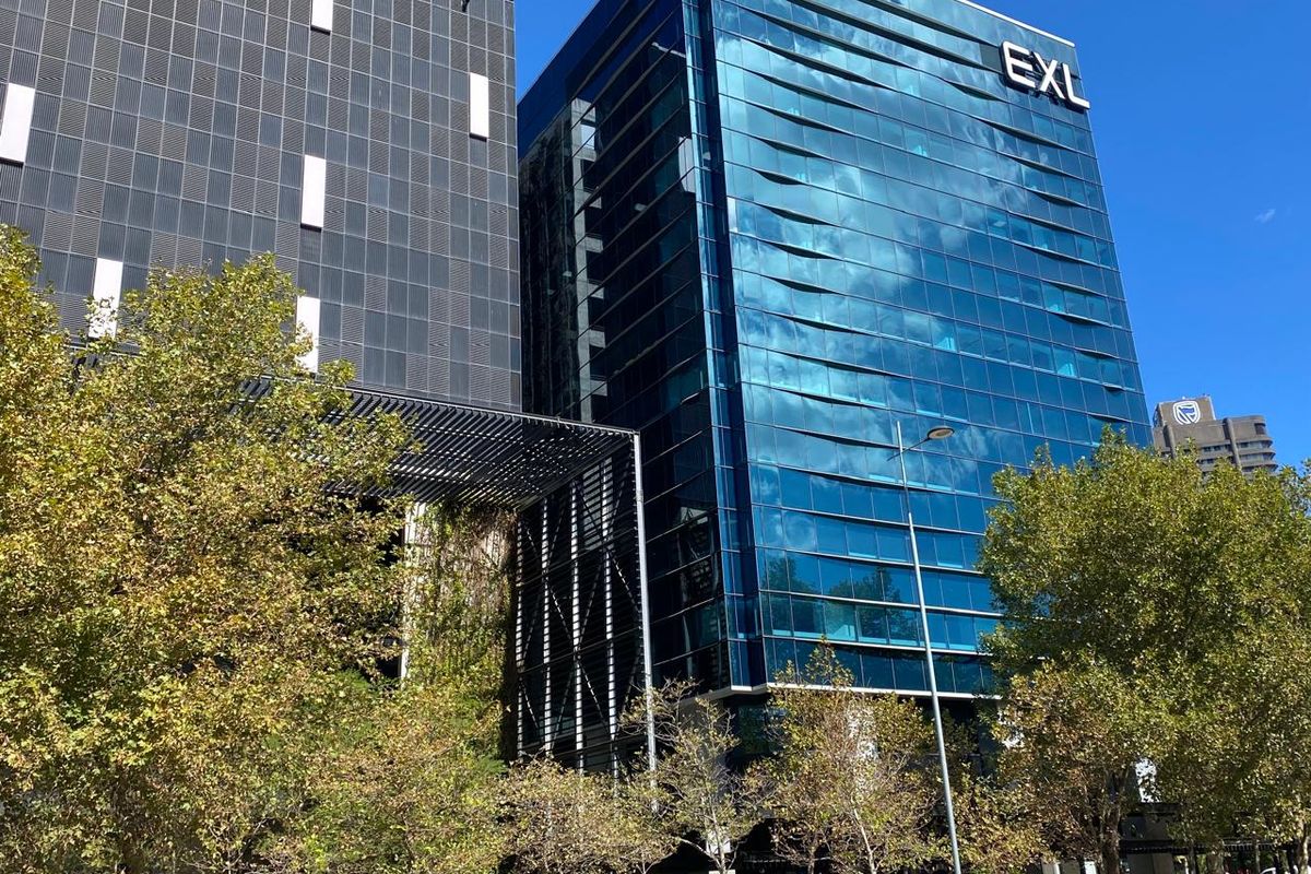 Modern high-rise commercial office building featuring a prominent glass curtain wall facade and contemporary architectural design.