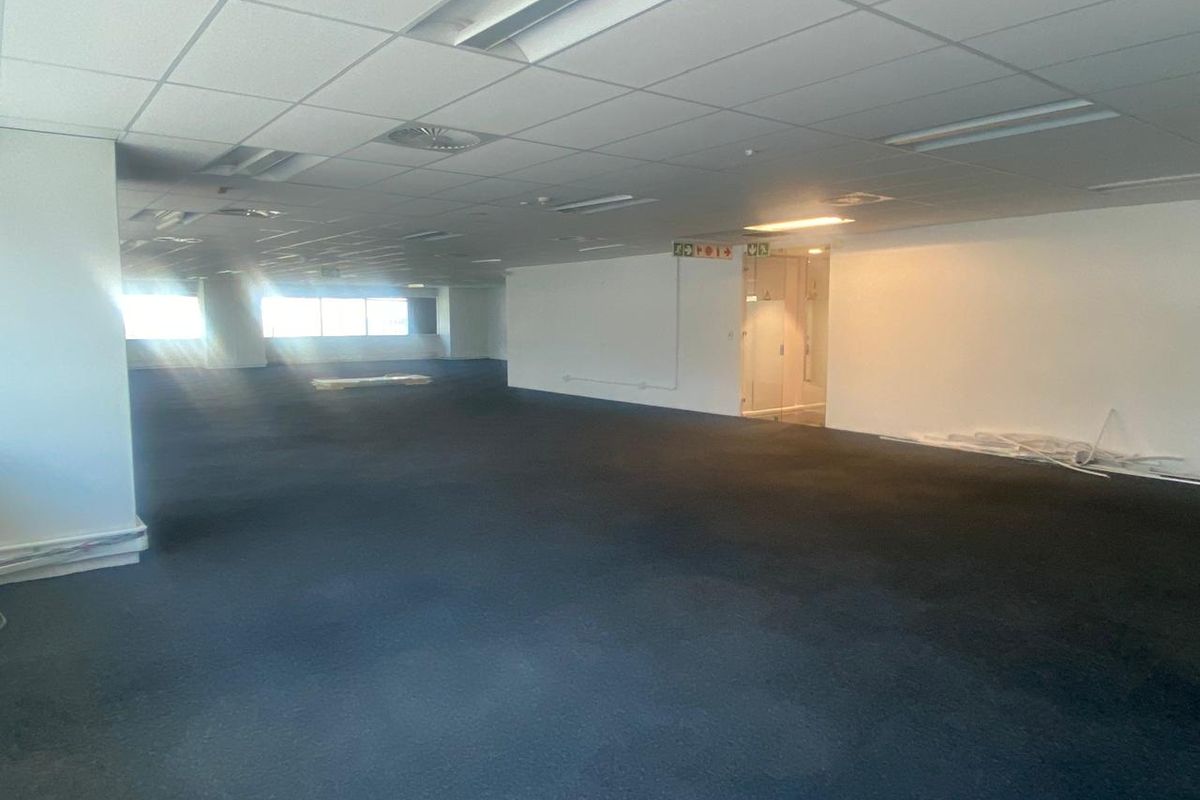 A large, open-plan office space featuring a suspended ceiling, recessed lighting, and expansive windows, currently vacant and ready for custom fit-out.