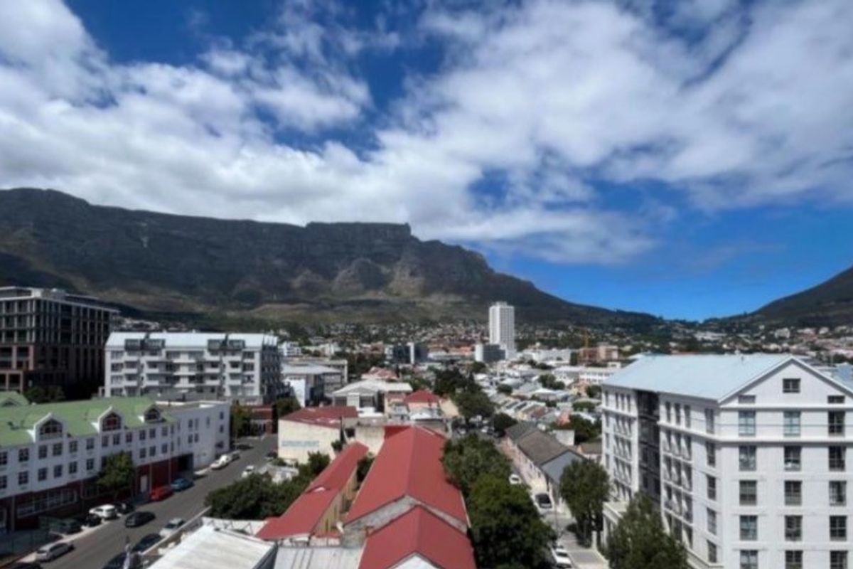 An elevated panoramic view of the surrounding urban landscape and mountain range, showcasing the property's prime location and scenic outlook.