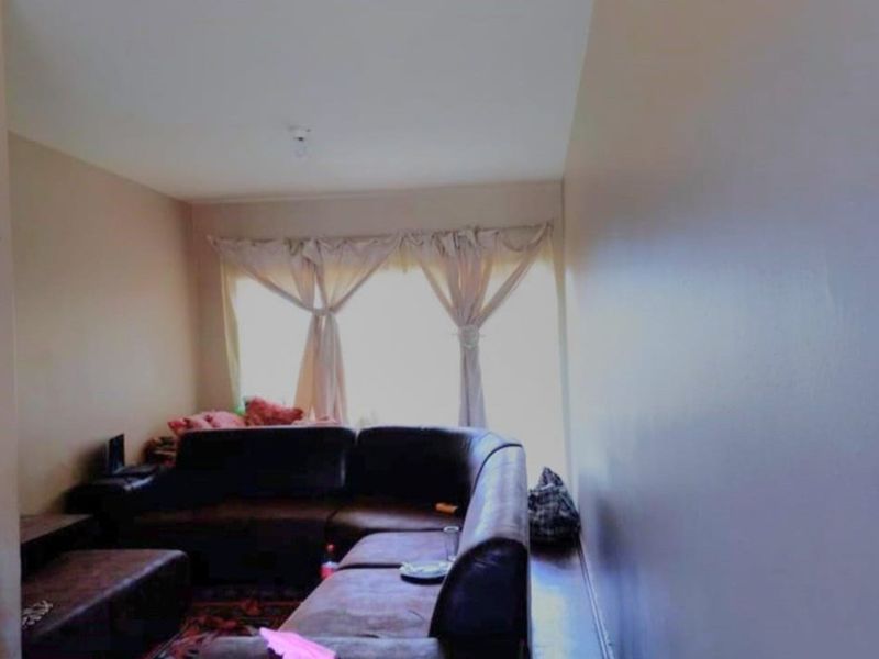 A living room area featuring a large window that provides natural light to the space.