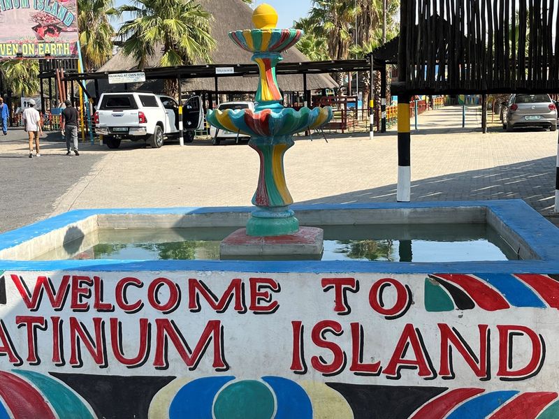 Exterior view of the entrance area featuring a decorative water fountain and paved parking space at Platinum Island.