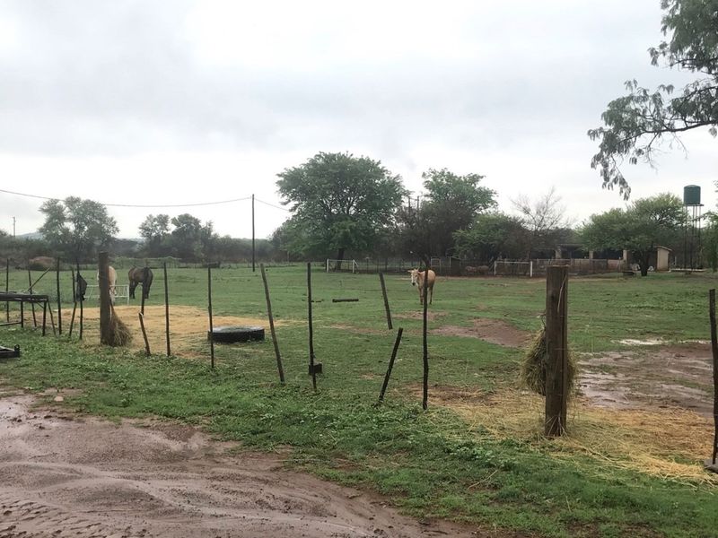 Expansive rural outdoor area featuring open grazing land, basic wire fencing, and a water storage tank on the property grounds.