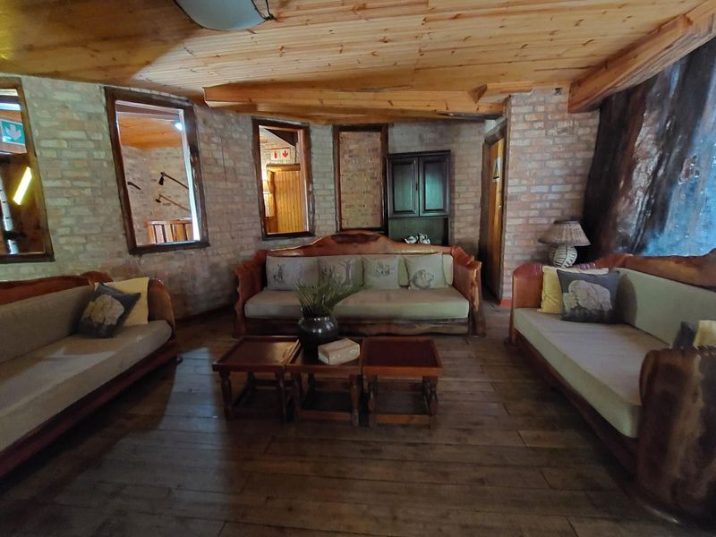 Rustic living area featuring exposed brick walls, timber plank ceiling, and timber flooring, creating a warm and traditional atmosphere.