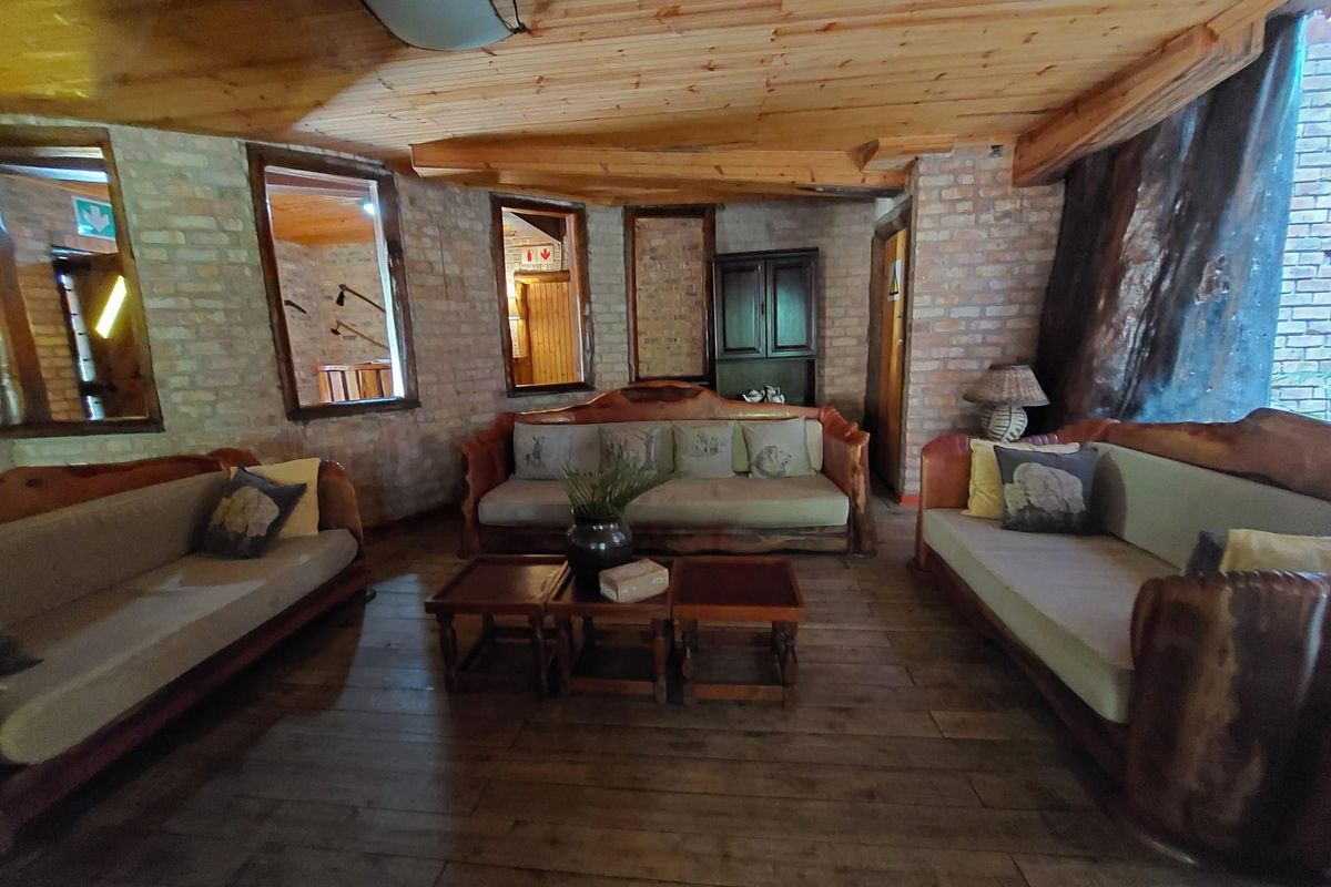 Rustic living area featuring exposed brick walls, timber plank ceiling, and timber flooring, creating a warm and traditional atmosphere.