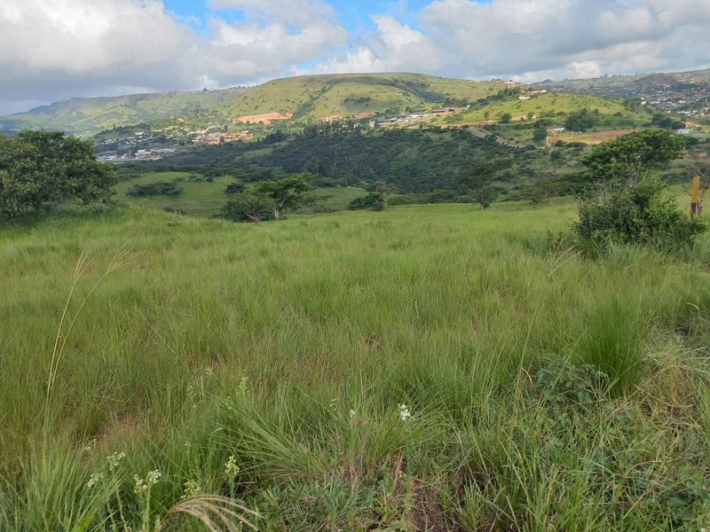 Expansive view of rolling green hills and natural landscape, showcasing the scenic surroundings of the commercial property location.