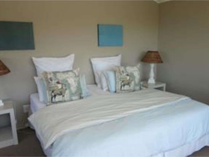 A standard bedroom featuring neutral wall paint and carpeted flooring.