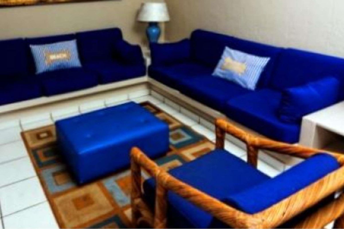 A living room area featuring tiled flooring, presented in a dated style.
