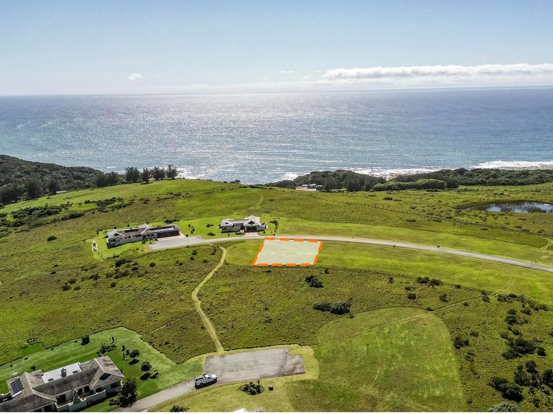 Aerial view of a vacant residential plot situated in a coastal estate, featuring expansive ocean views and direct road access.