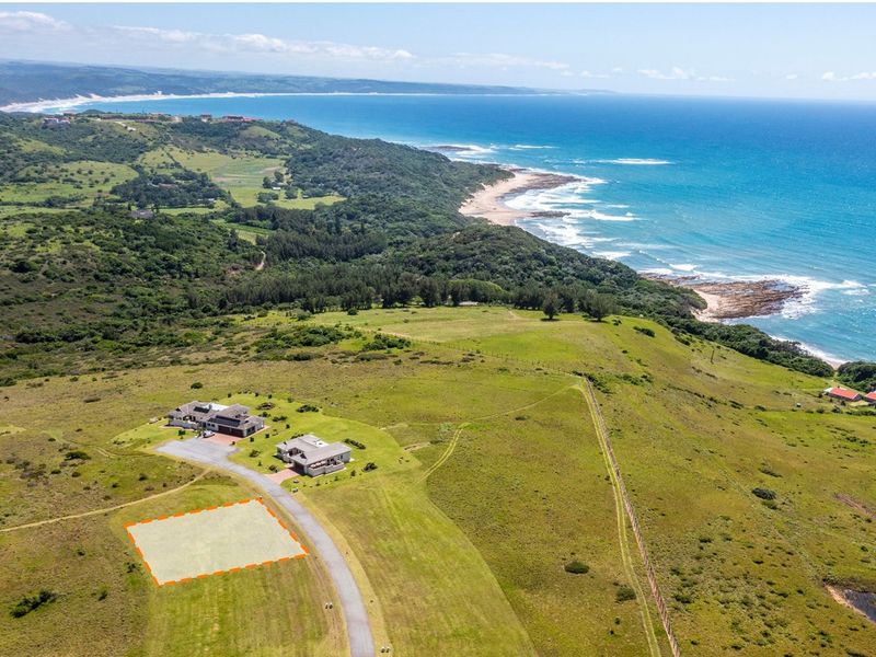 Aerial view of a vacant residential plot situated in a coastal estate with scenic ocean and landscape views.