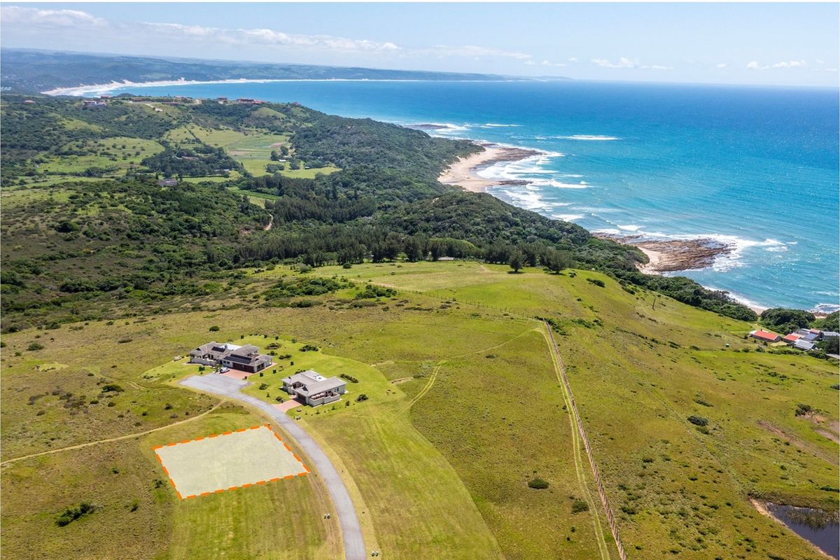 Aerial view of a vacant residential plot situated in a coastal estate with scenic ocean and landscape views.
